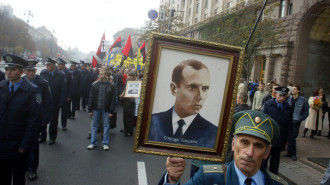 A partisan veteran from the Ukrainian Insurgent Army carries a portrait of Ukrainian Insurgent Army leader Stepan Bandera during a march in Kiev. (AP Photo/Efrem Lukatsky)