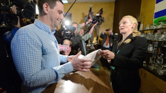 Iraq war veteran Sean Azzariti (L) purchases legal recreational marijuana from Toni Fox at the Denver Discreet Disensary in Denver, Colorado, USA